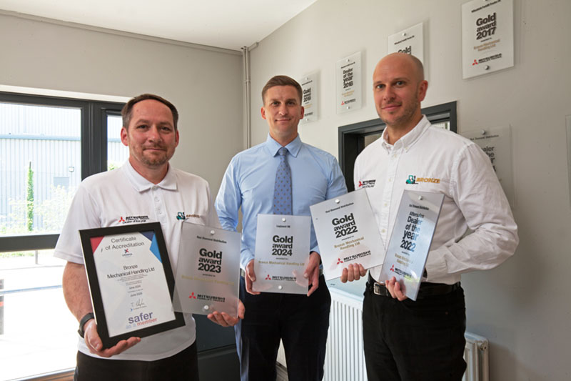 Three people holding awards